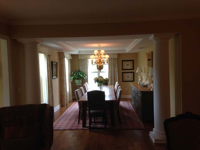 Formal dining room with columns and tray ceiling.